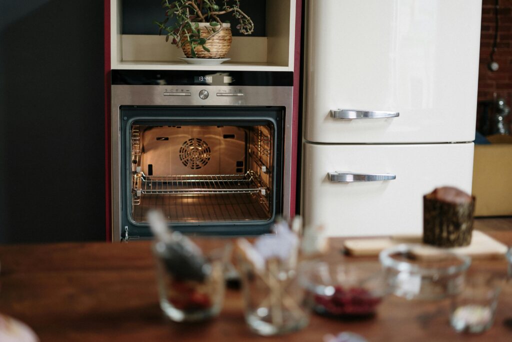 A warm kitchen scene featuring an open oven and a wooden table in a cozy home setting.